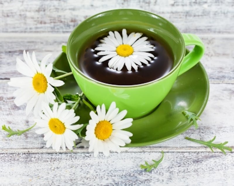 there is a cup of tea with a flower in it