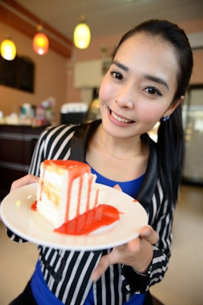 woman holding a plate with a piece of cake on it