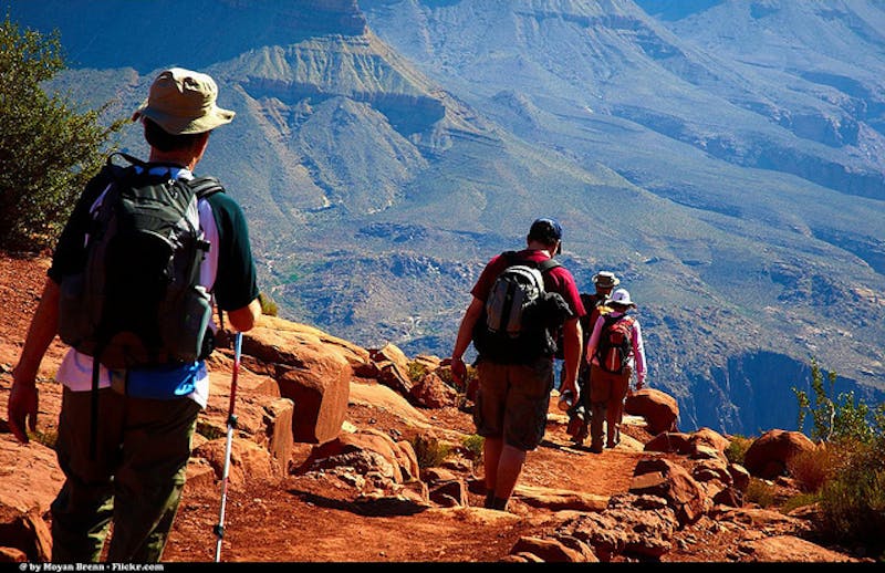 several people hiking up a steep mountain with a view of the mountains