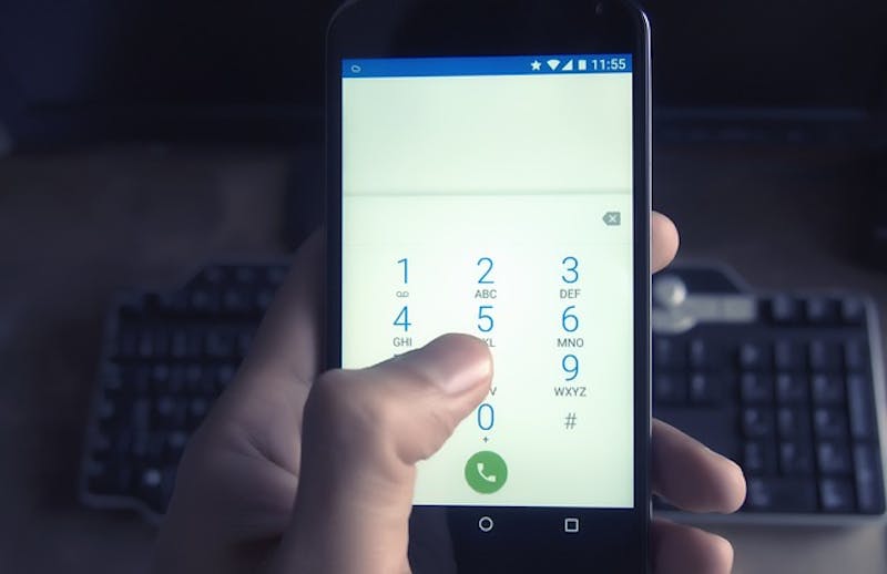 someone is holding a cell phone dialing a number