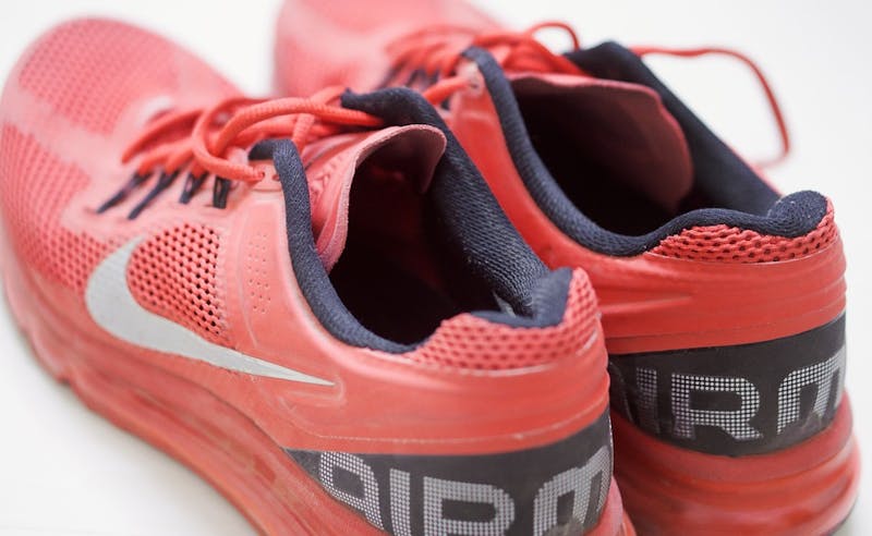 nike air max running shoes with a red sole and black laces sitting on a white background