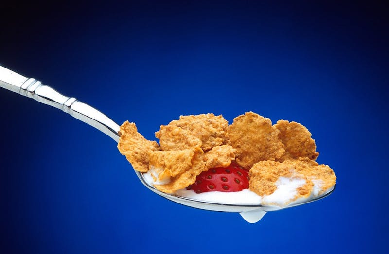 cereal with milk and strawberries on a spoon