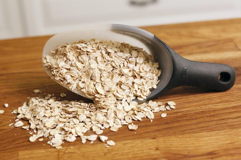 a close up of a scoop of oats on a wooden table