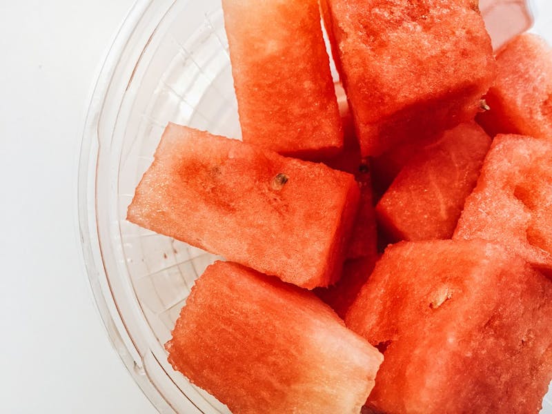 there is a bowl of watermelon cubes on a table