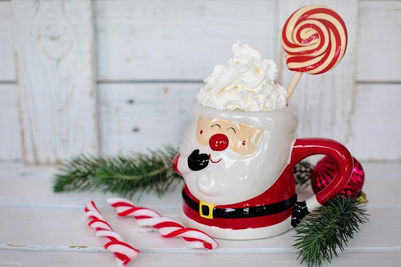 there is a santa claus mug with a lollipop in it