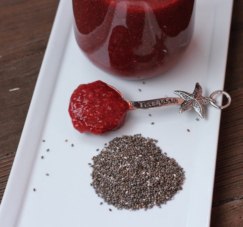 there is a jar of chia seeds and a spoon on a plate