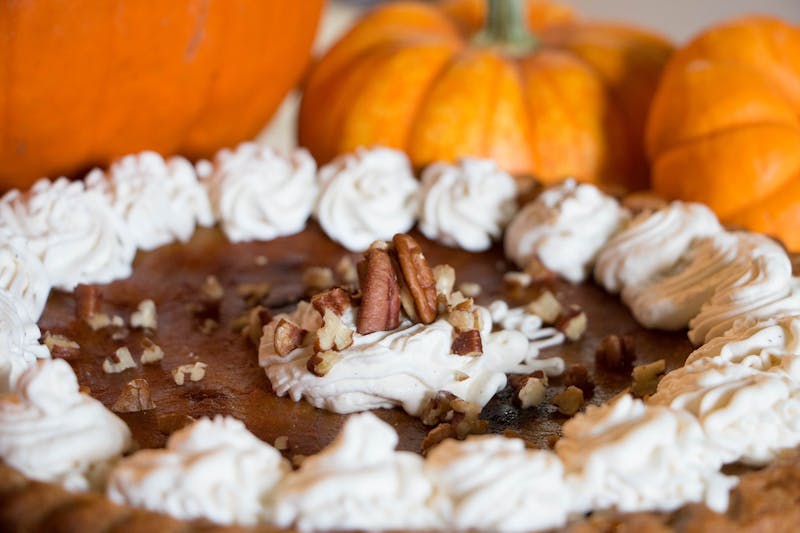 there is a cake with white frosting and pecans on it