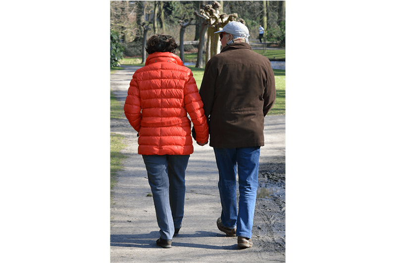 couple are walking down the road holding hands