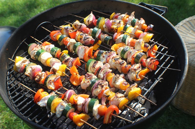 a close up of a grill with skewers of different types of food on it