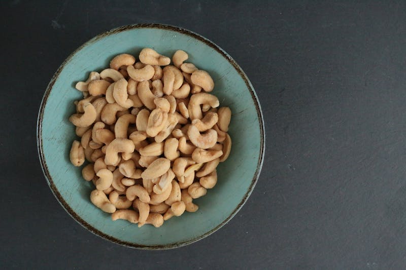 bowl of cashews on a black surface