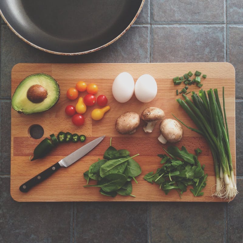 there are many vegetables and eggs on a cutting board on the counter
