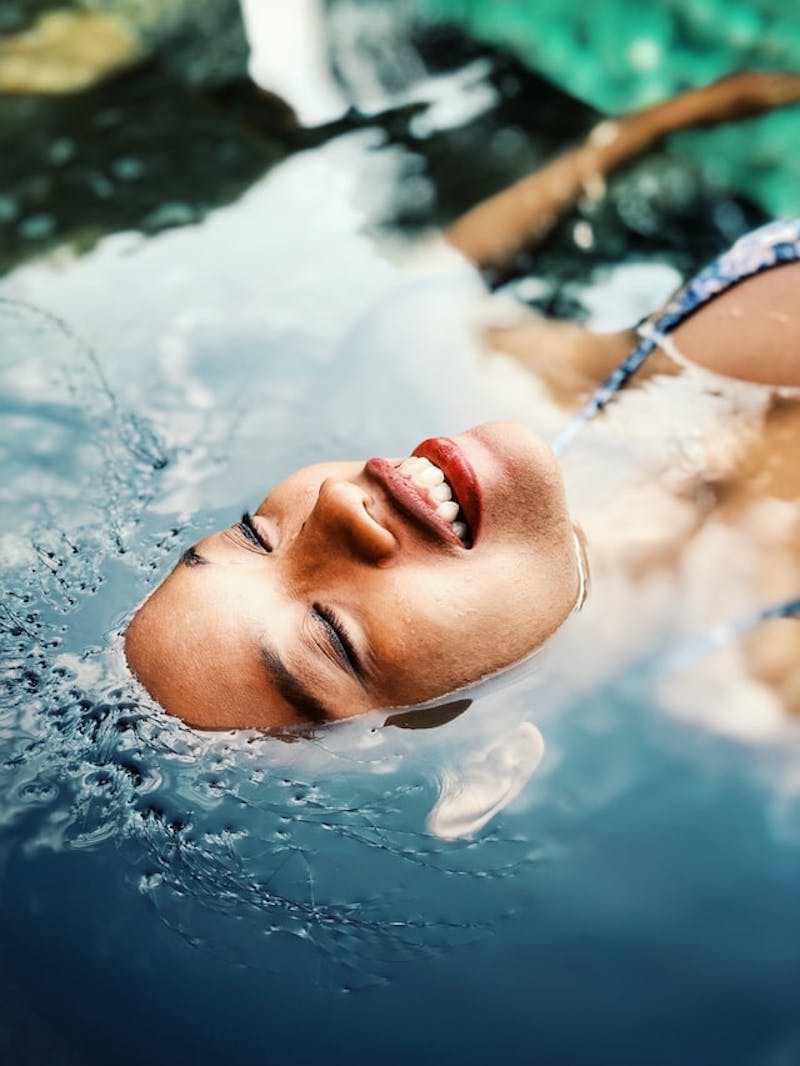 close up of a woman in a bikini laying in a pool