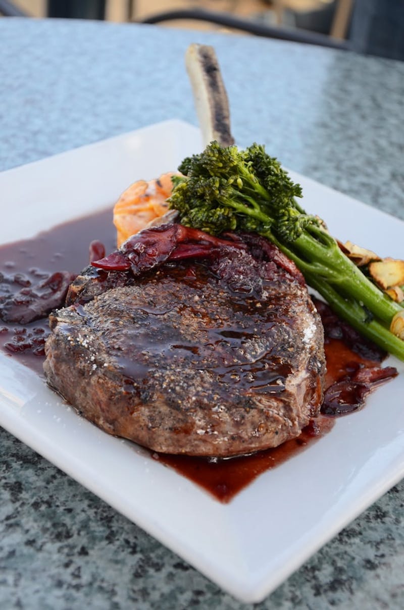 a lamb chop and vegetables on a plate on a table