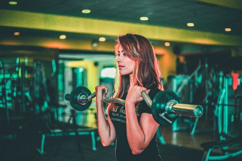 a woman is lifting weights in gym
