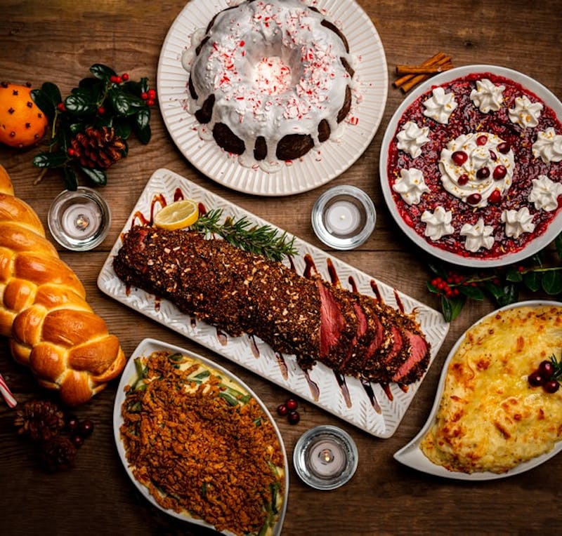 sliced meat on a platter with other dishes of food