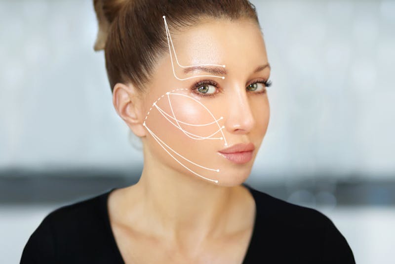 close up of a woman's face with lines drawn it and a black shirt