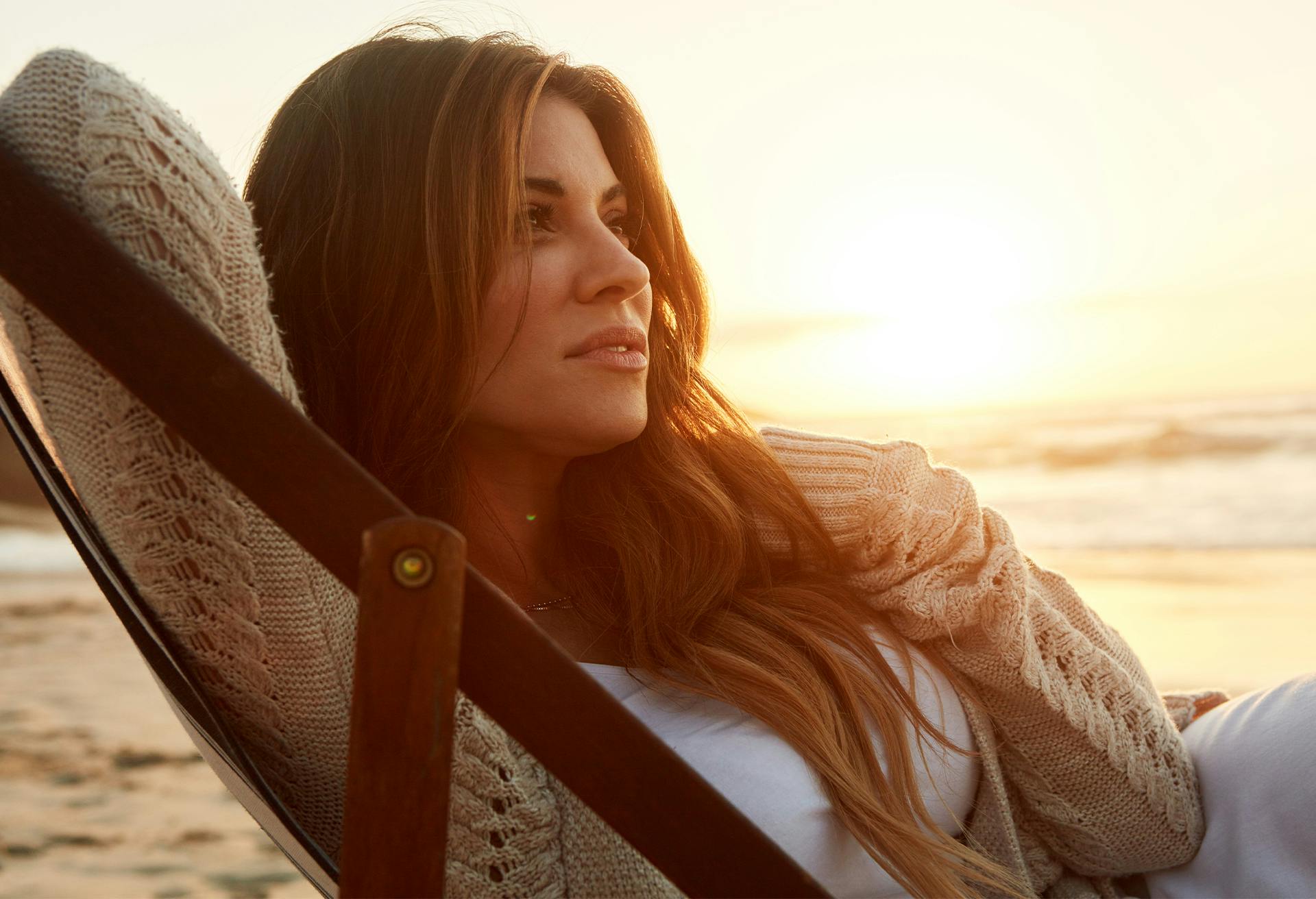 Woman sitting on a chair by the ocean