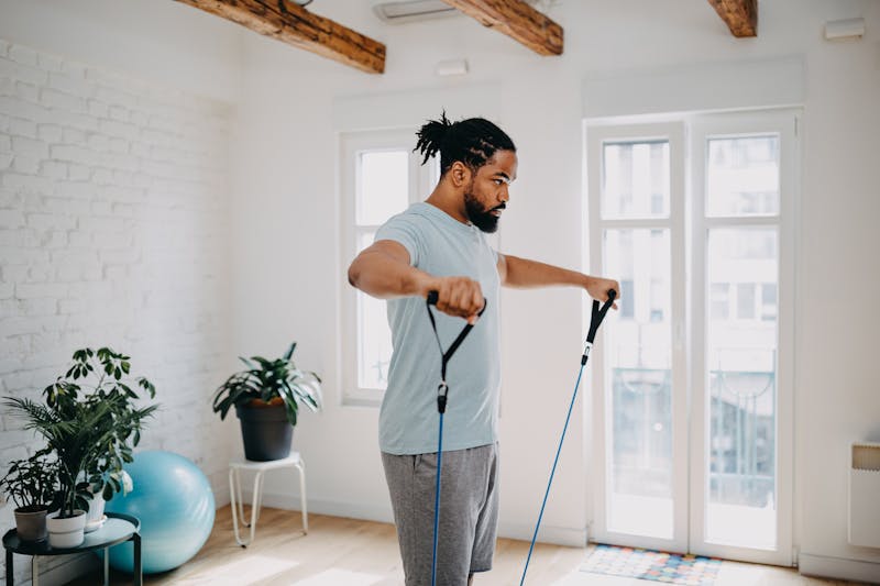 man using a resistance band in a living room