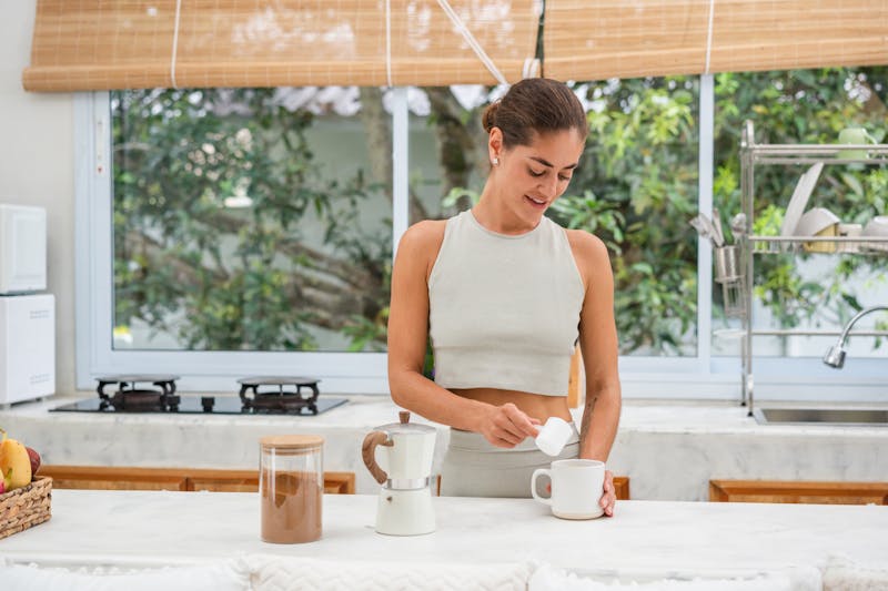 a woman that is standing in the kitchen preparing food