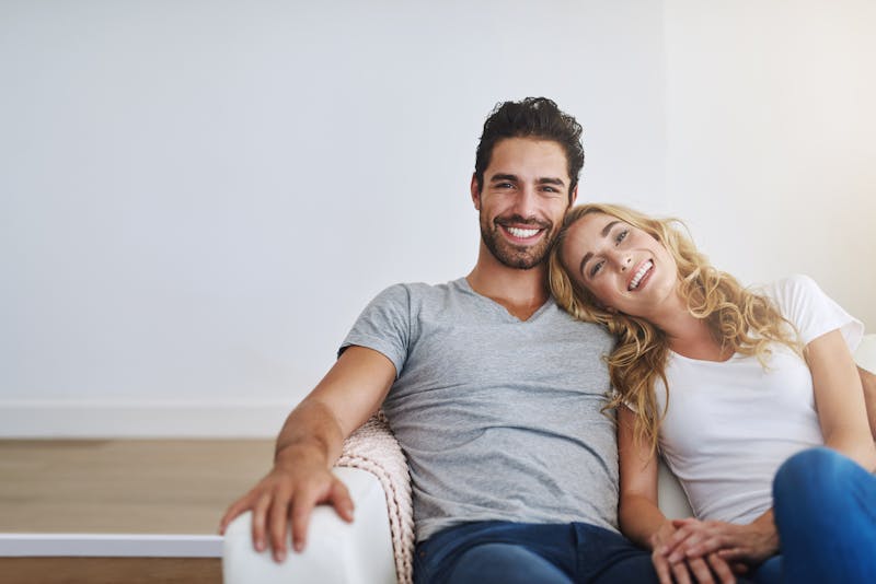 smiling couple sitting on a couch in a living room