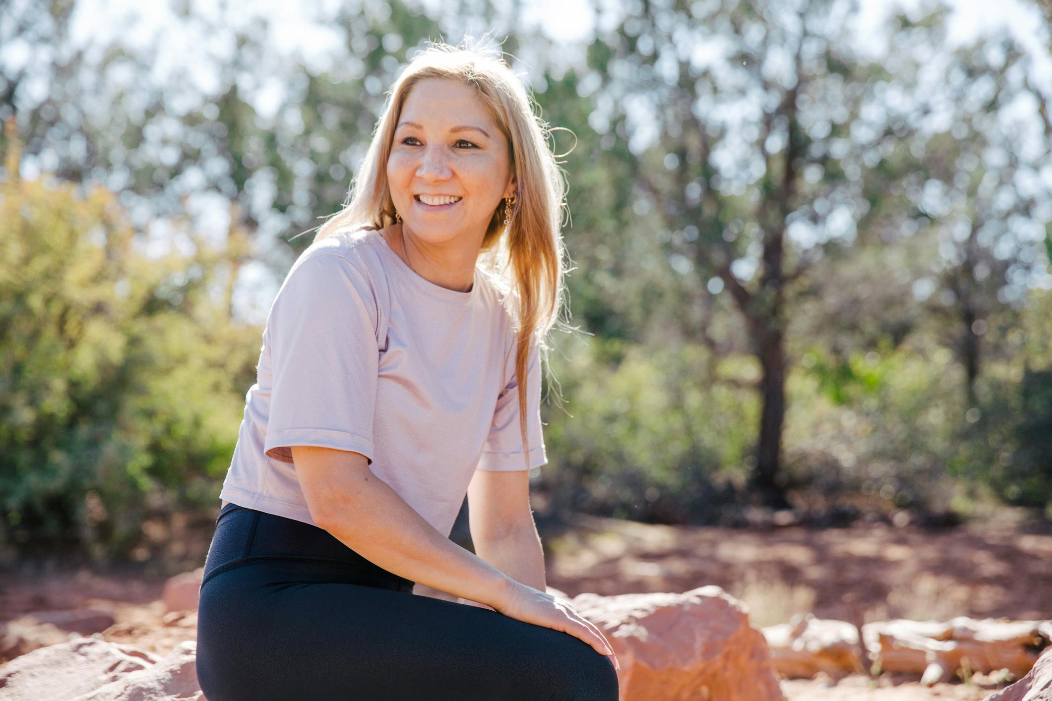 smiling blonde woman sitting in sunlight