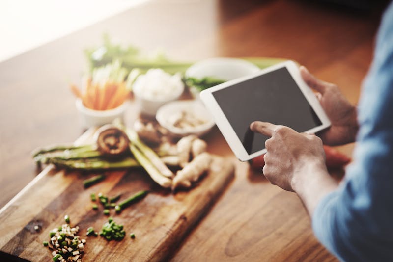 kitchen with vegetables while person using tablet