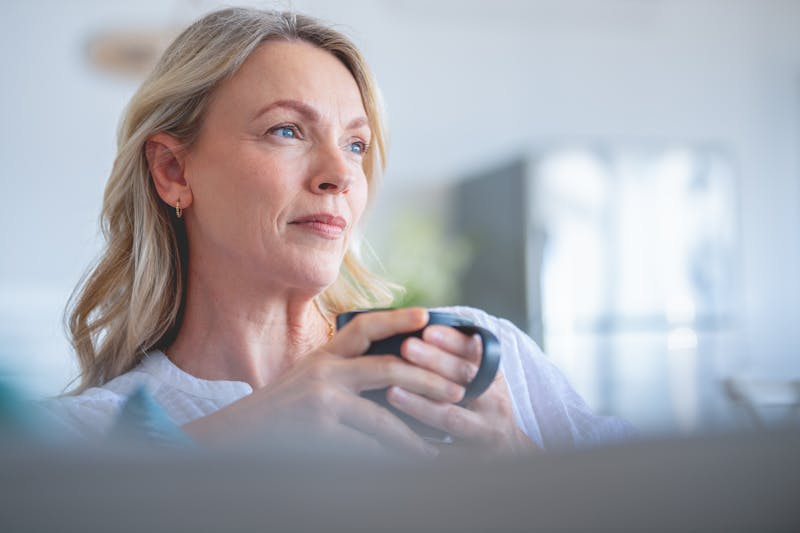 mature woman holding a black mug