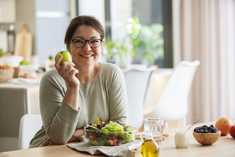 middle aged woman holding an apple