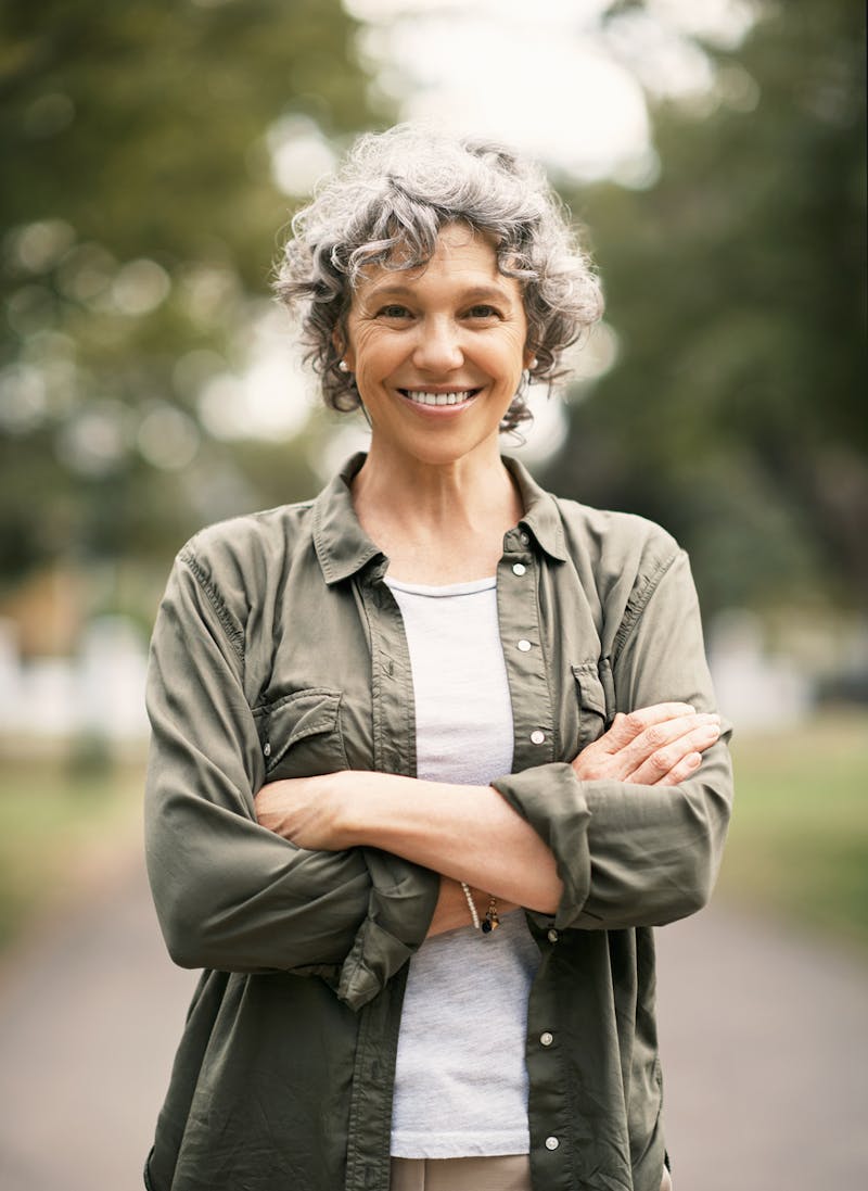 woman standing with arms crossed smiling