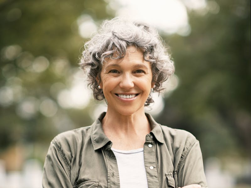 woman standing with arms crossed smiling