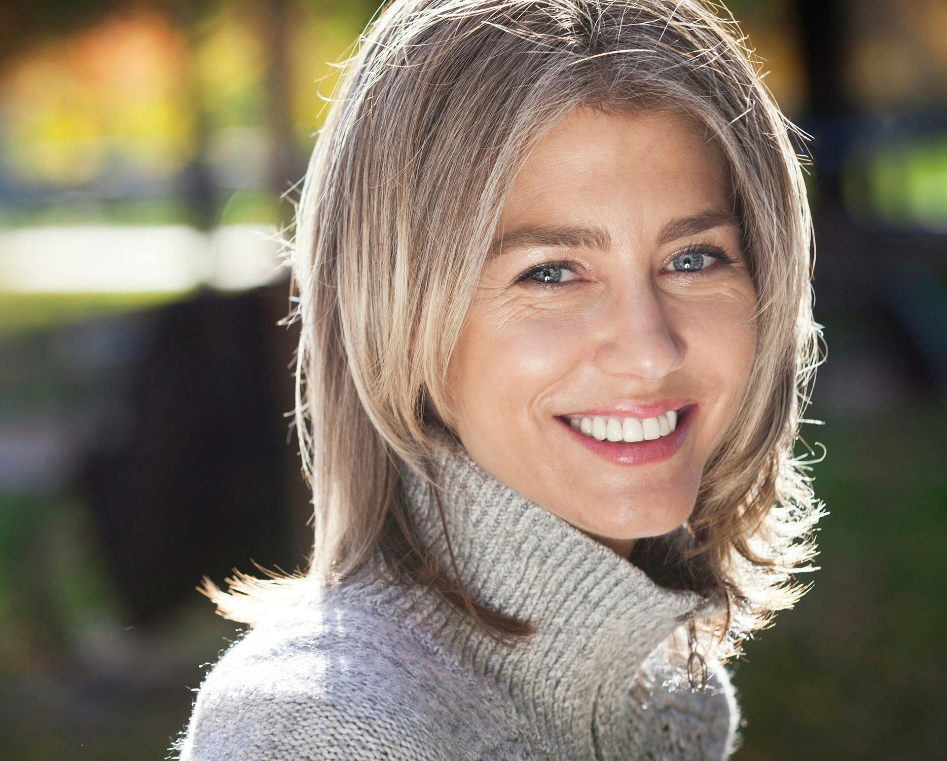 Middle-aged woman wearing grey turtleneck