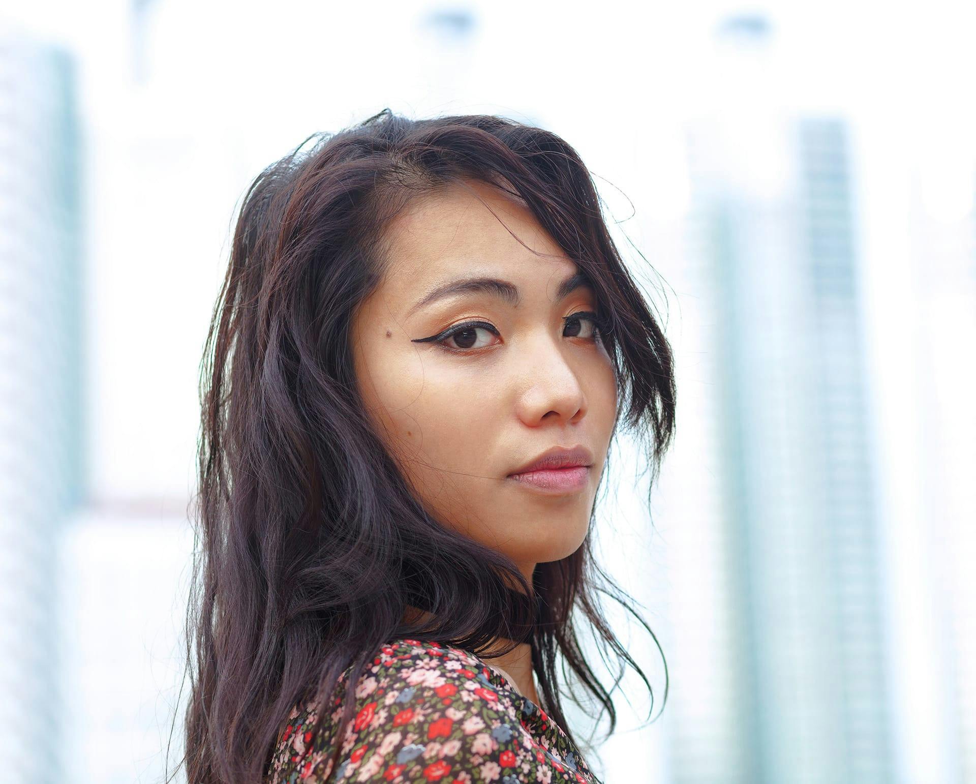 Woman in floral blouse wearing eyeliner