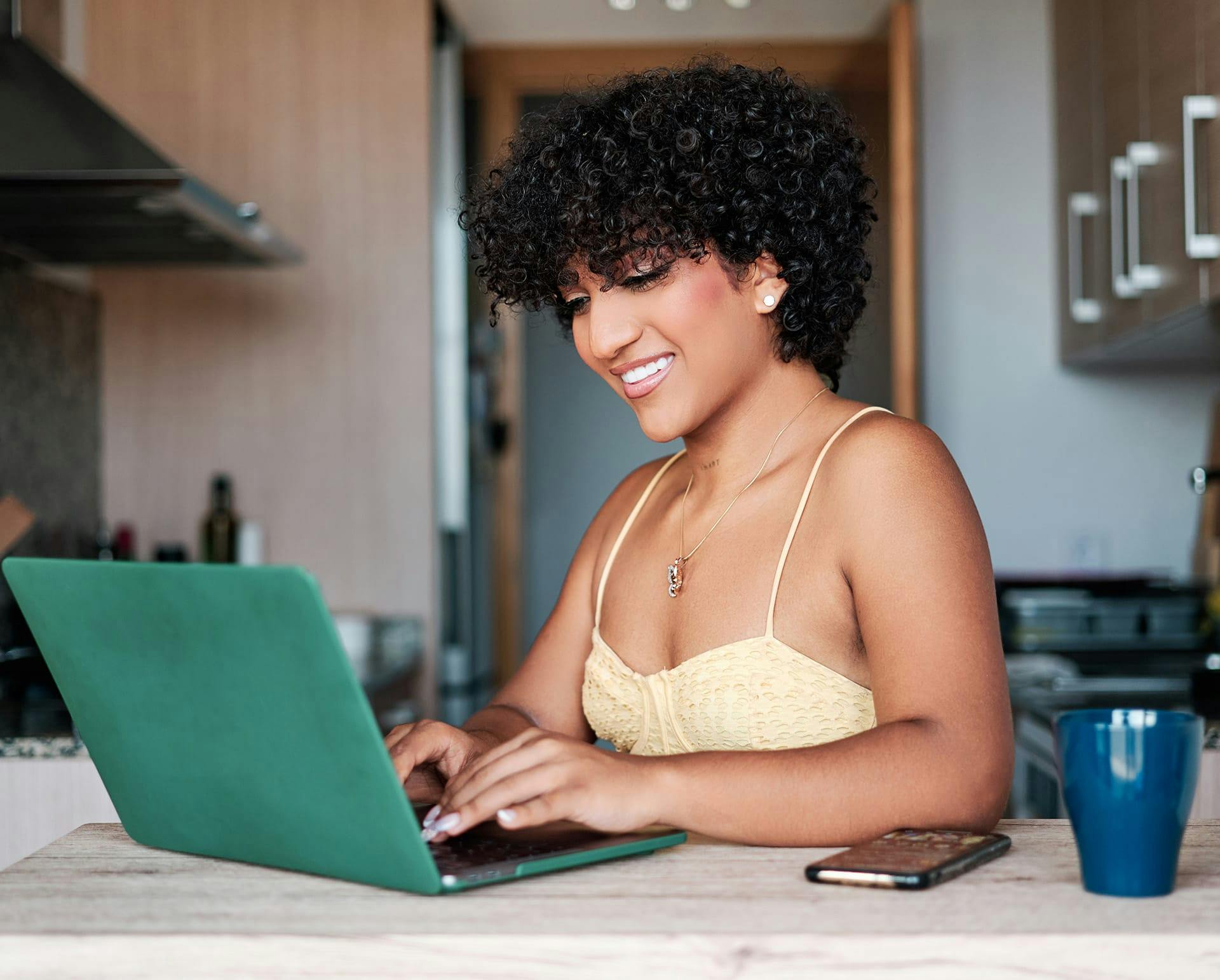 Woman in yellow top working on her laptop