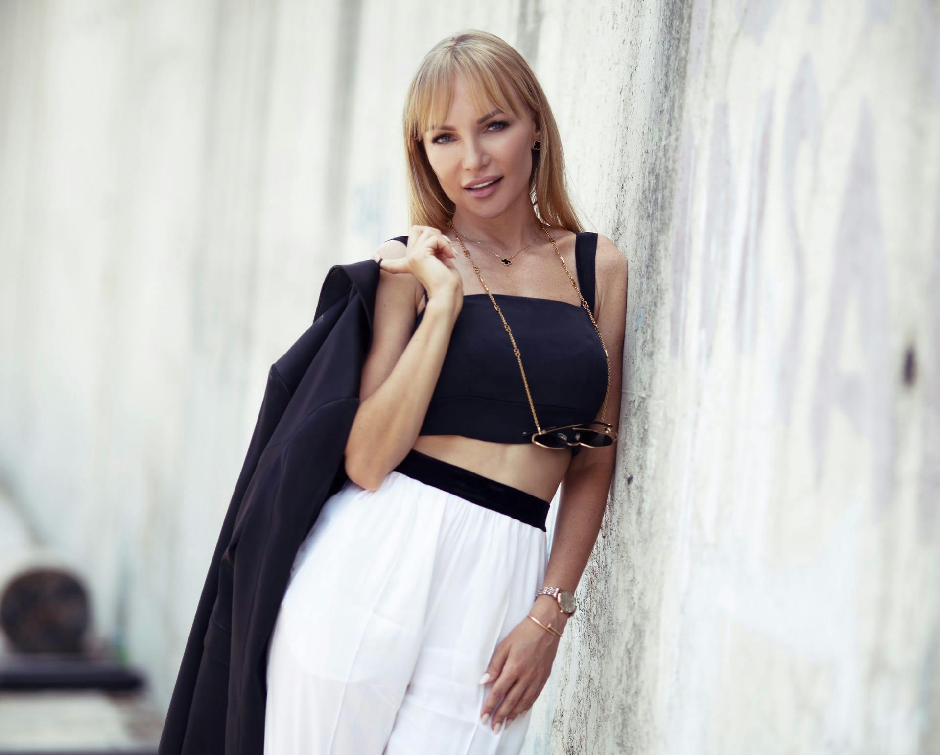 Blonde woman leaning on a wall