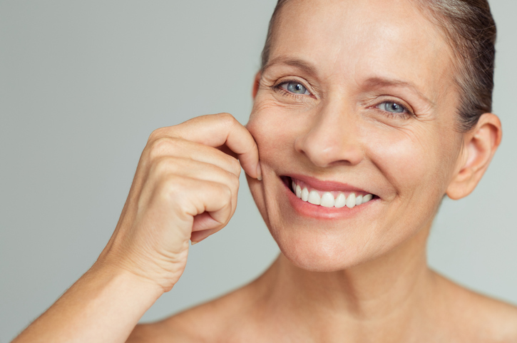 Woman smiling and pinching her cheek