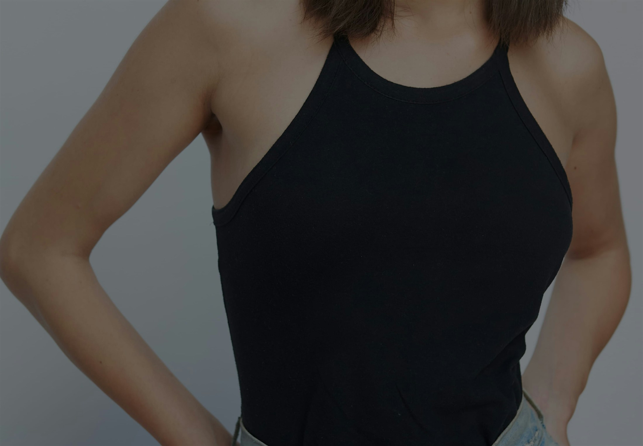 woman in a black top and jeans posing for a picture