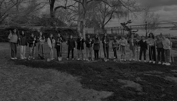 A group of upper school students posing with shovels in Carl Schurz Park as part of the community engagement work