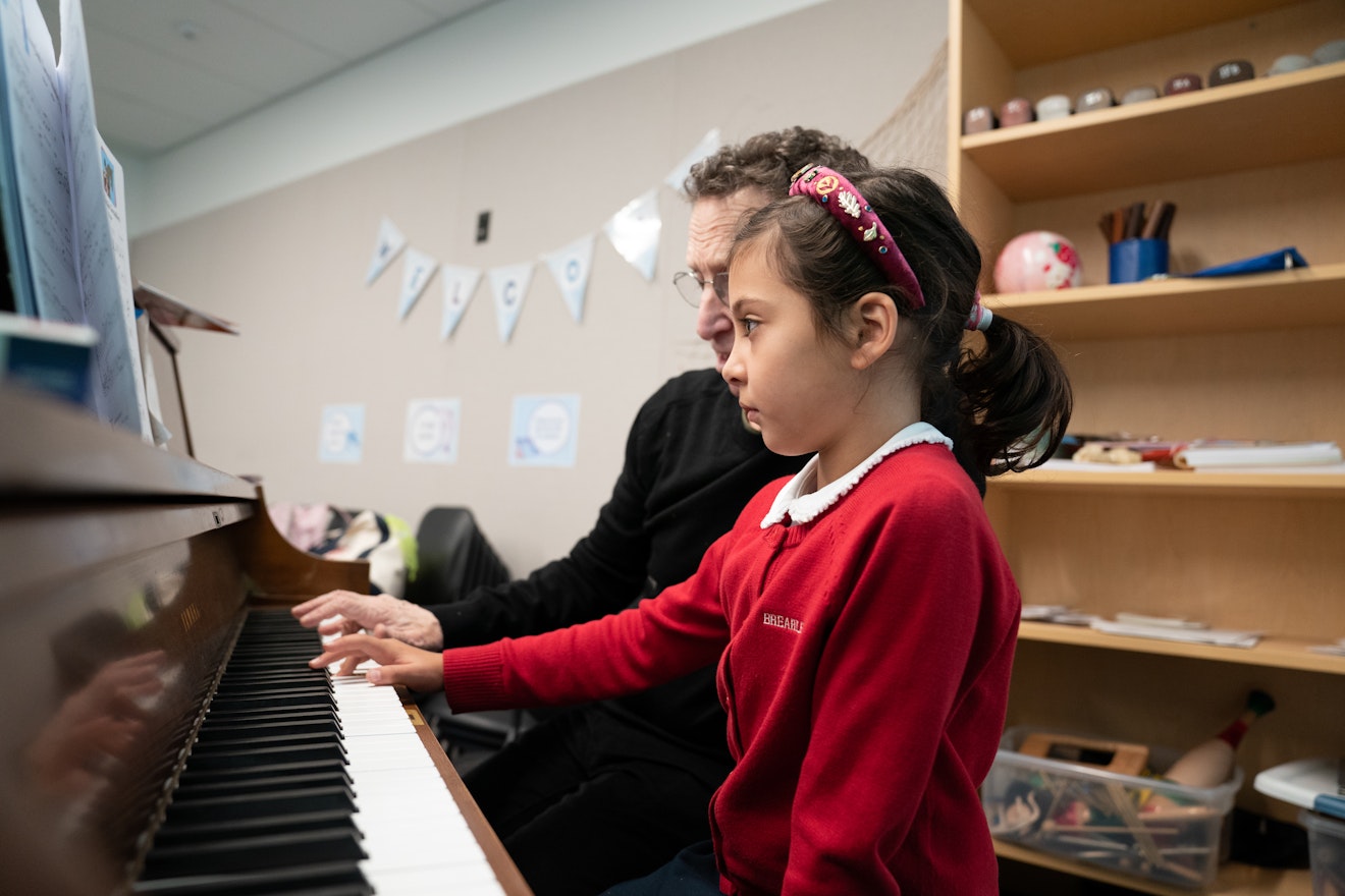 A lower school student receiving private piano lessons