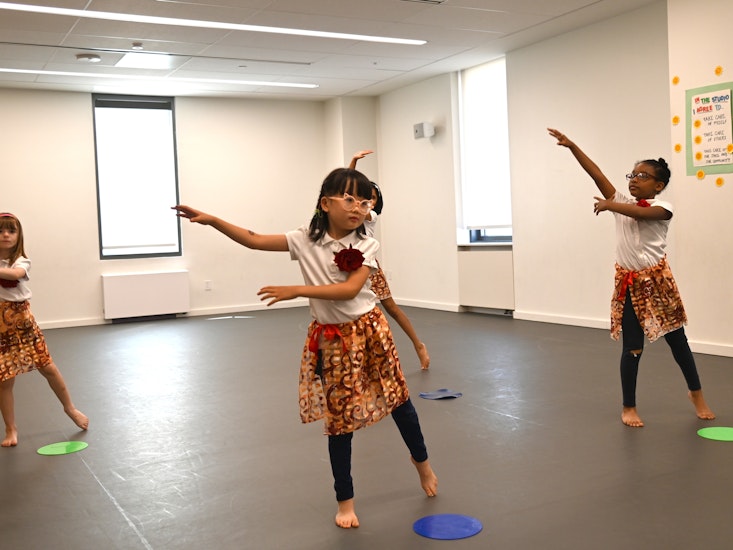 Lower School students performing a dance dressed in colorful skirts in the 590 buildings dance studio
