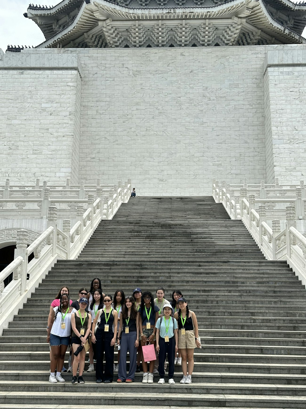 Upper School students on their trip to Taiwan posing on the stairs of a very large temple