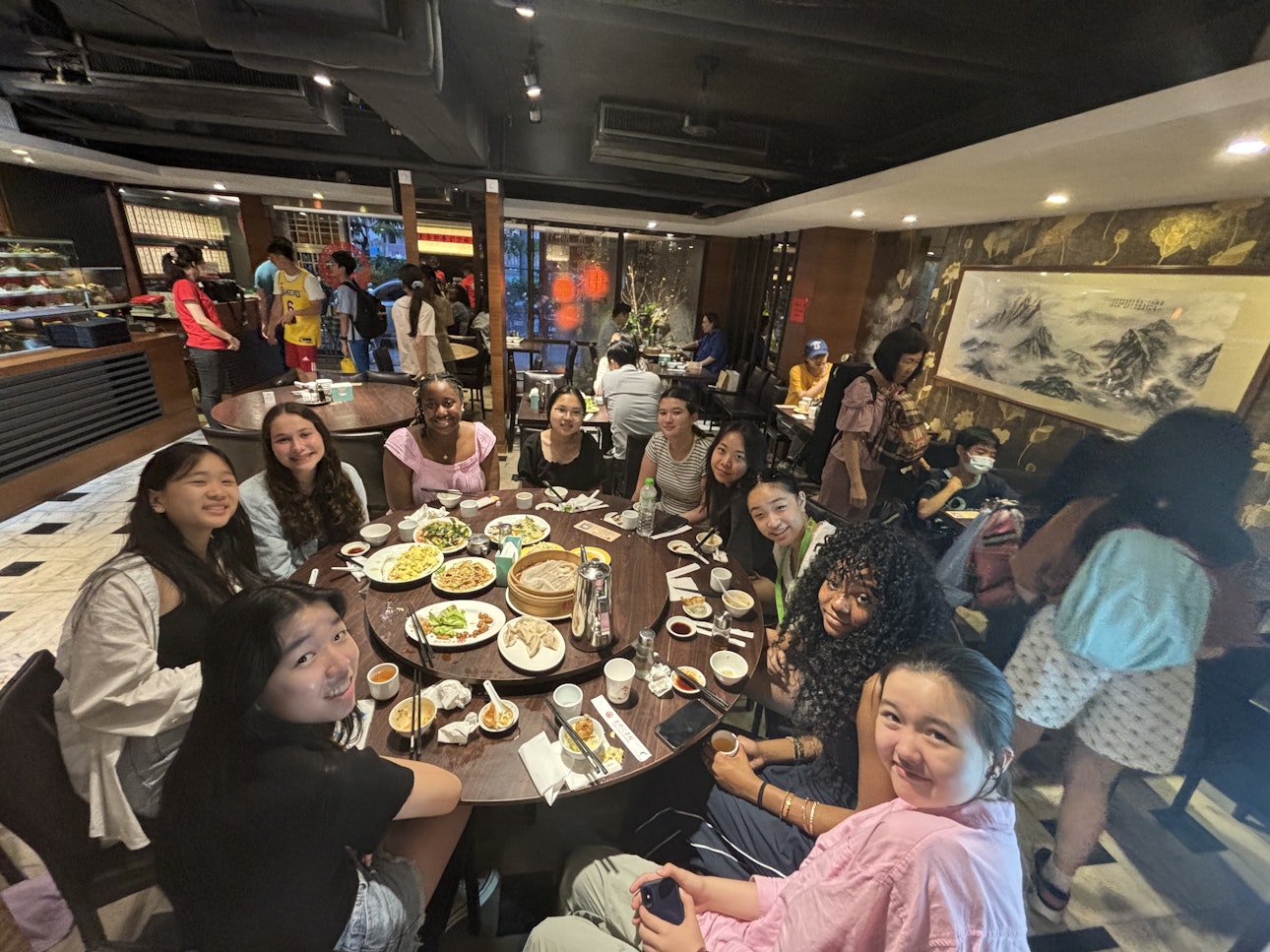 Upper School students sitting around a table of really good food on their trip to Taiwan
