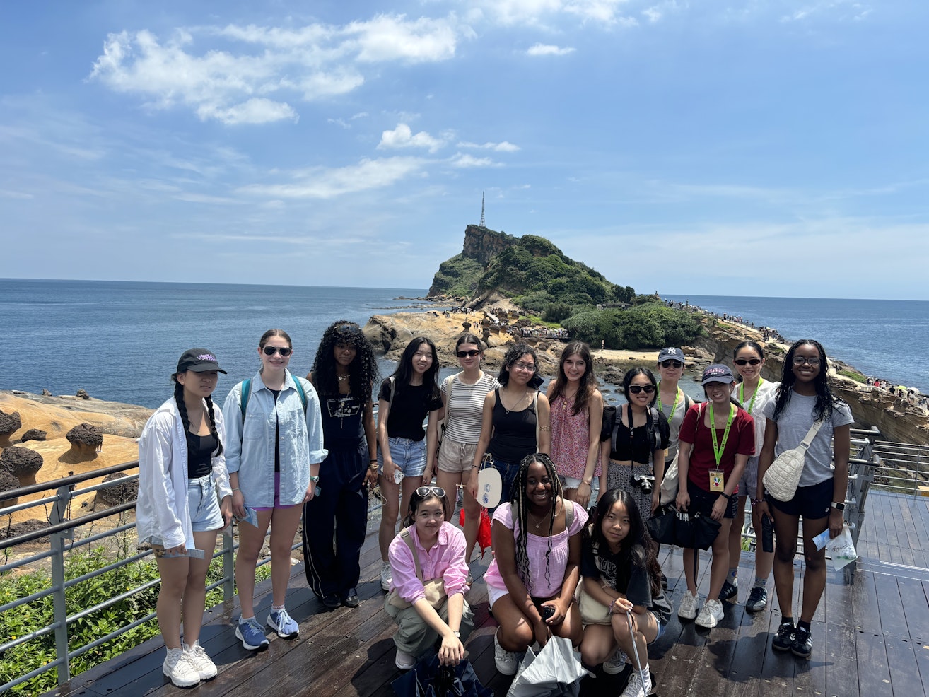 Upper School students on their trip to Taiwan posing in front of a beautiful sea scape.