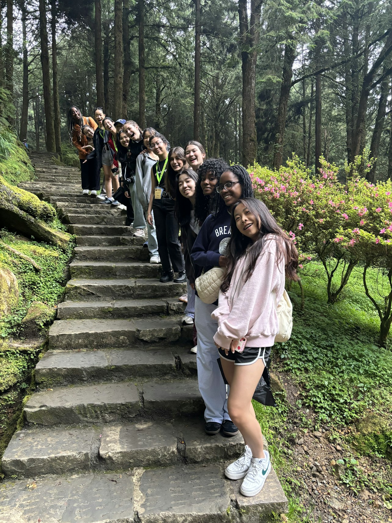 Upper School students on their trip to Taiwan lined up a set of stone stairs in a garden