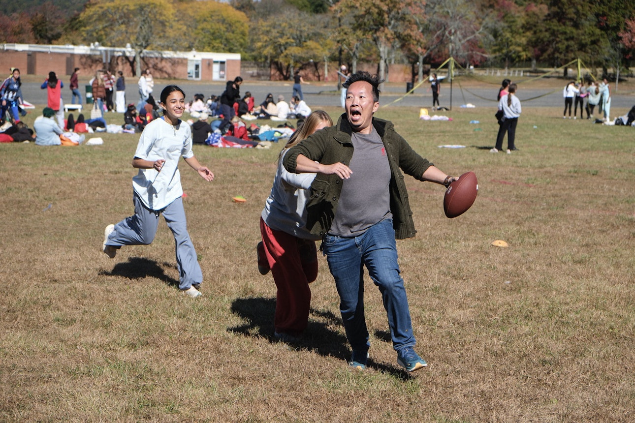 A Brearley teacher holding a football and running away from a student chasing him during one of the activities held during Mountain Day.