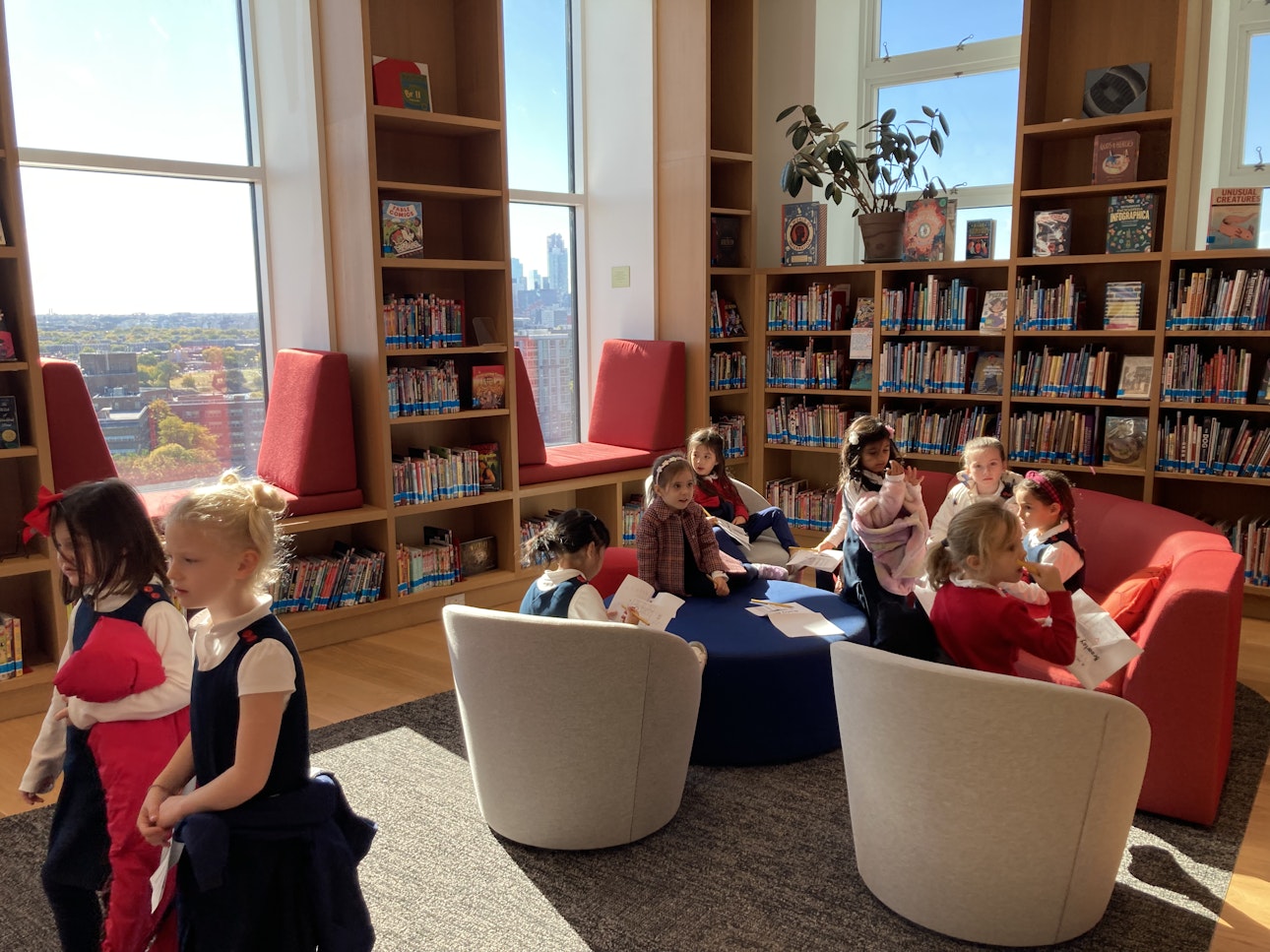 Kindergarten students enjoy the newly renovated Middle School library with it's comfy chairs and light-filled spaces, surrounded by books.