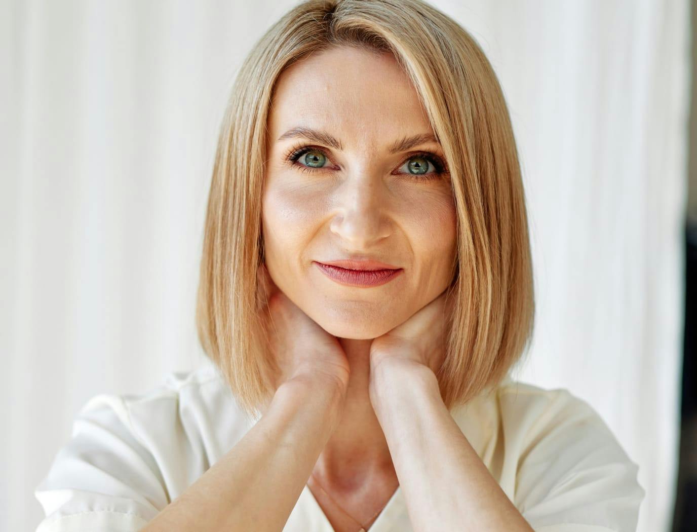 Smiling woman supporting her neck