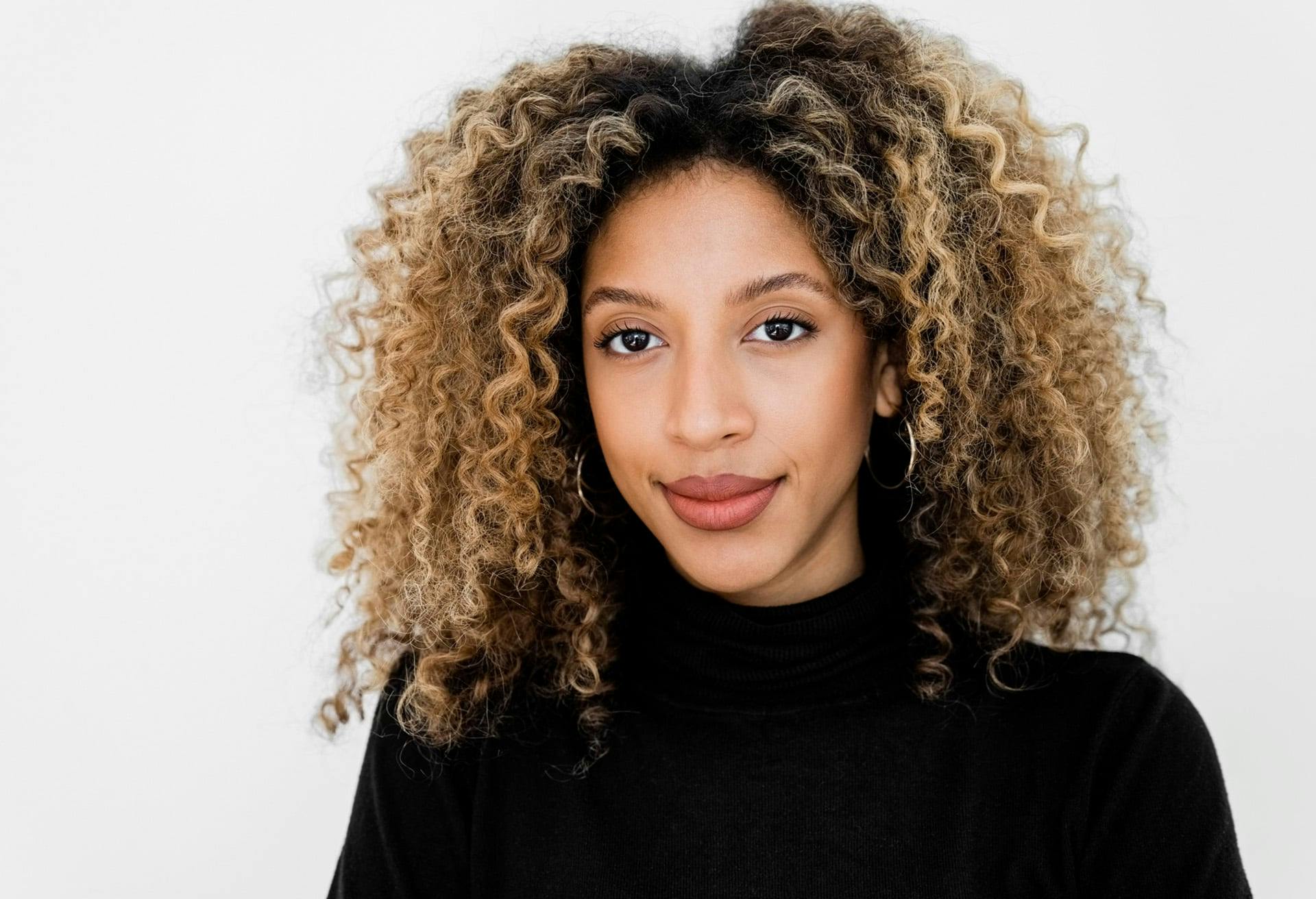 Woman wearing a black turtleneck smiling