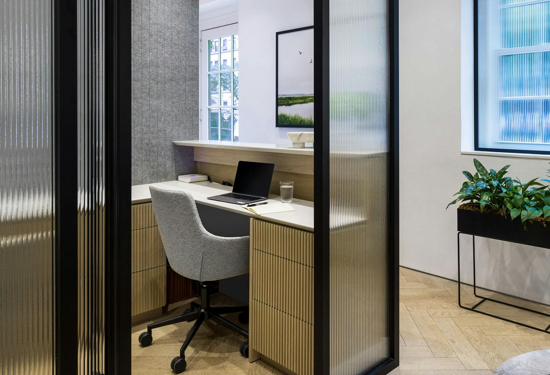 there is a desk with a laptop and a chair in a room
