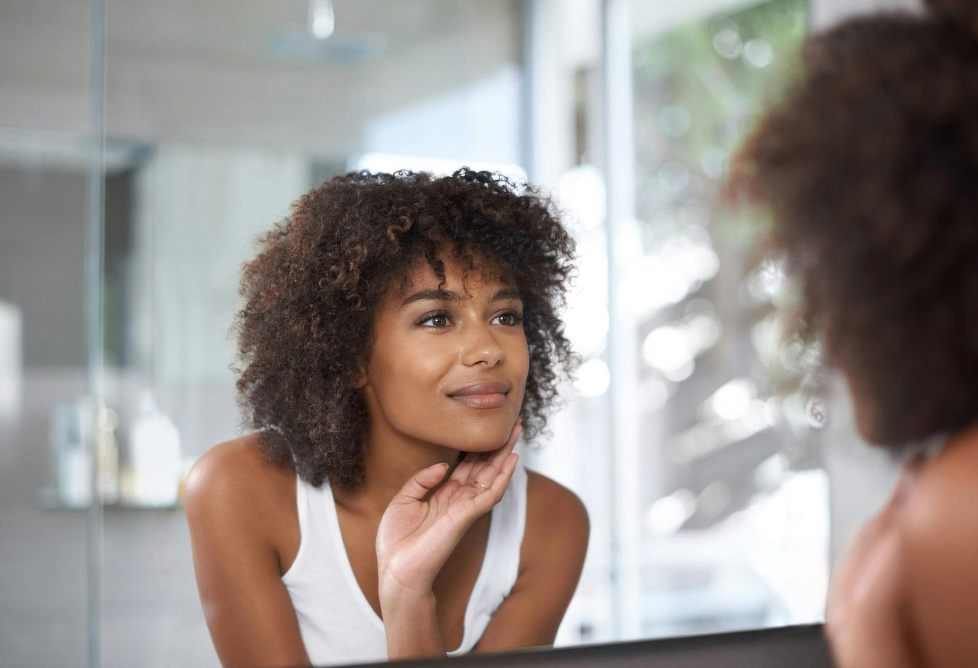 there is a woman looking at her reflection in the mirror