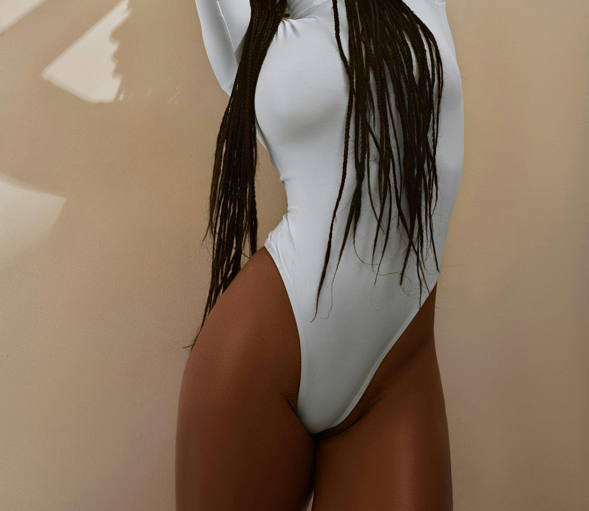 there is a woman in a white bodysuit posing for a picture